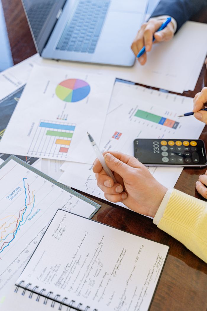 gallery-02 A close-up of businesspeople analyzing financial data and charts during a meeting.