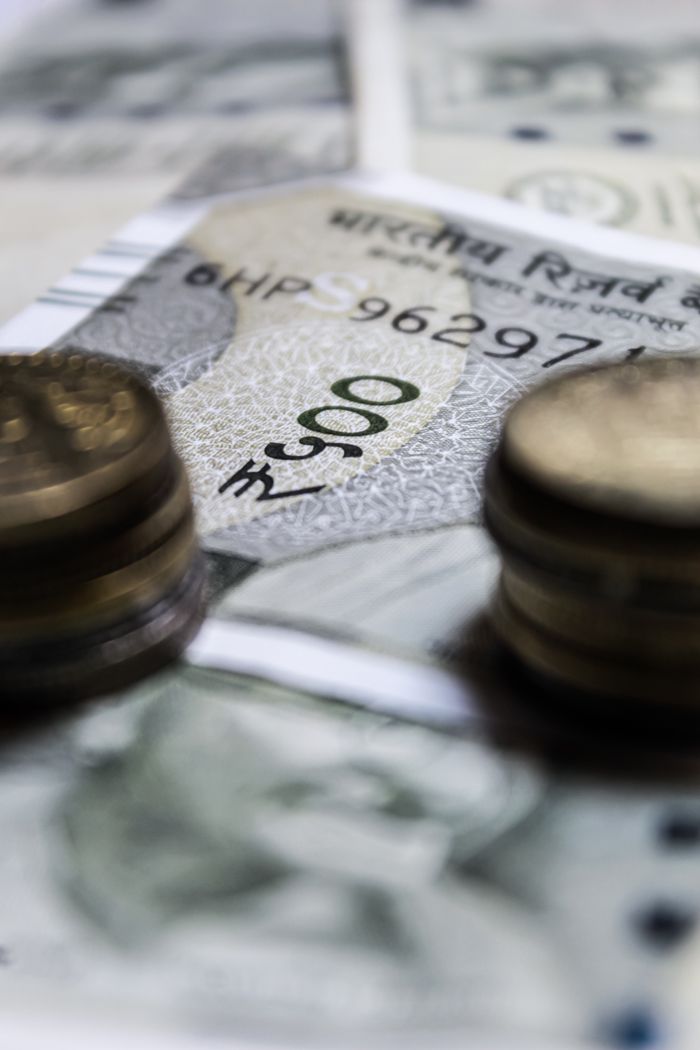 our-story Macro view of Indian currency featuring rupees and coins, showcasing financial abundance.